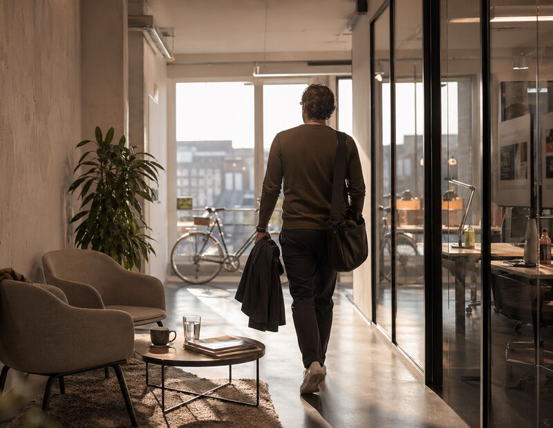 Ein Mann verlässt das Büro mit einer Sporttasche