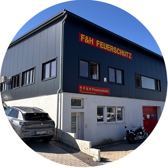 Das Gebäude von F&H Feuerschutz zeigt ein modernes Design mit klaren Linien und auffälligem Schild.